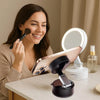 A woman holds a foldable magnetic phone holder device on a desk.