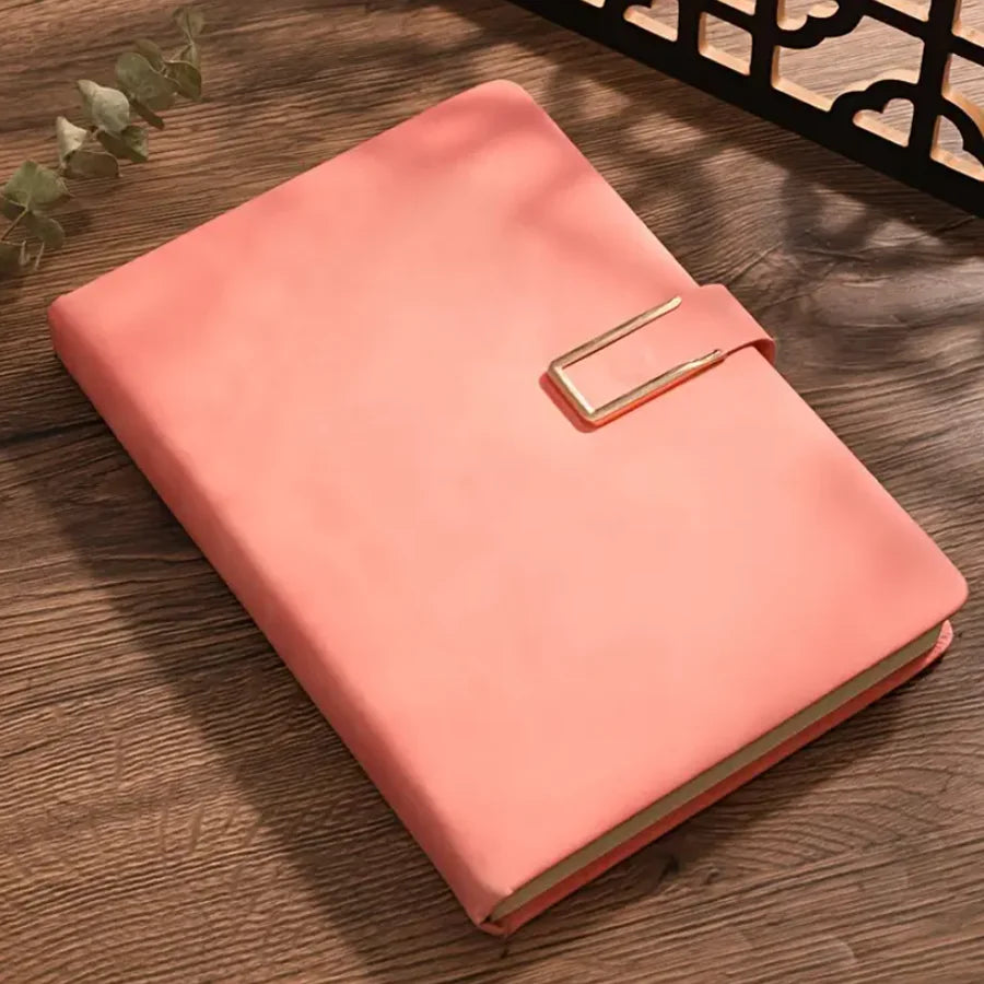 A pink A5 retro leather notebook lying on a wooden surface.