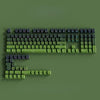 A close-up view of a green mechanical keyboard featuring Gradient Gray double shot PBT keycaps with side printing.
