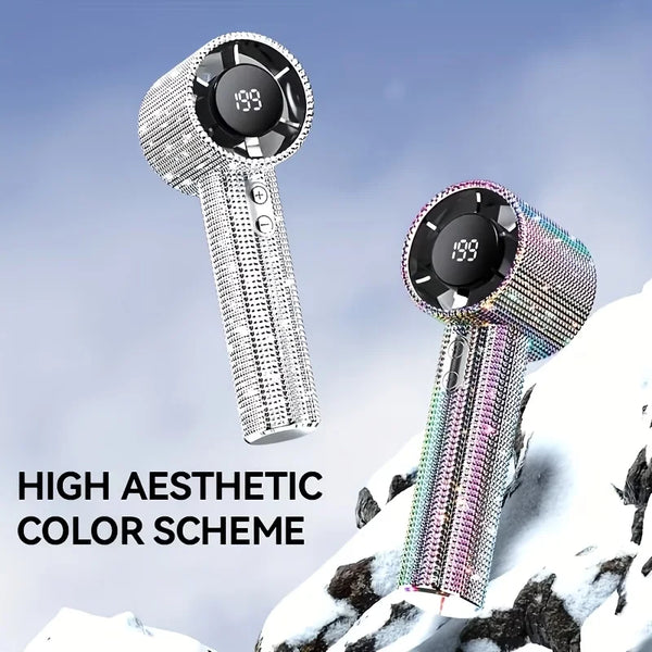 A sparkling diamond portable handheld fan with an LED display is shown against a snowy outdoor background.
