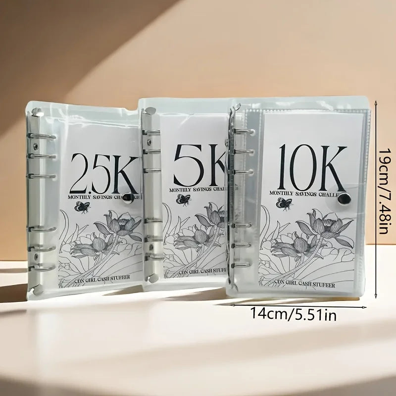 A set of three clear plastic binders for monthly savings challenges labeled 25K, 5K, and 10K.