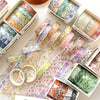 A collection of five rolls of floral washi tape in various colors and patterns displayed on a white surface.