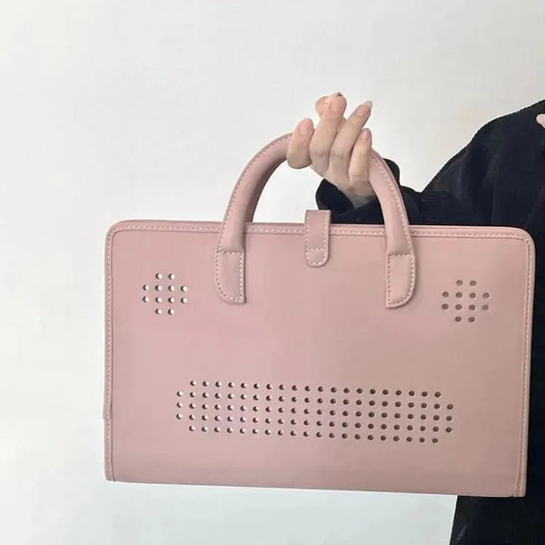 A pink laptop sleeve with a handle is held by a person against a white background.
