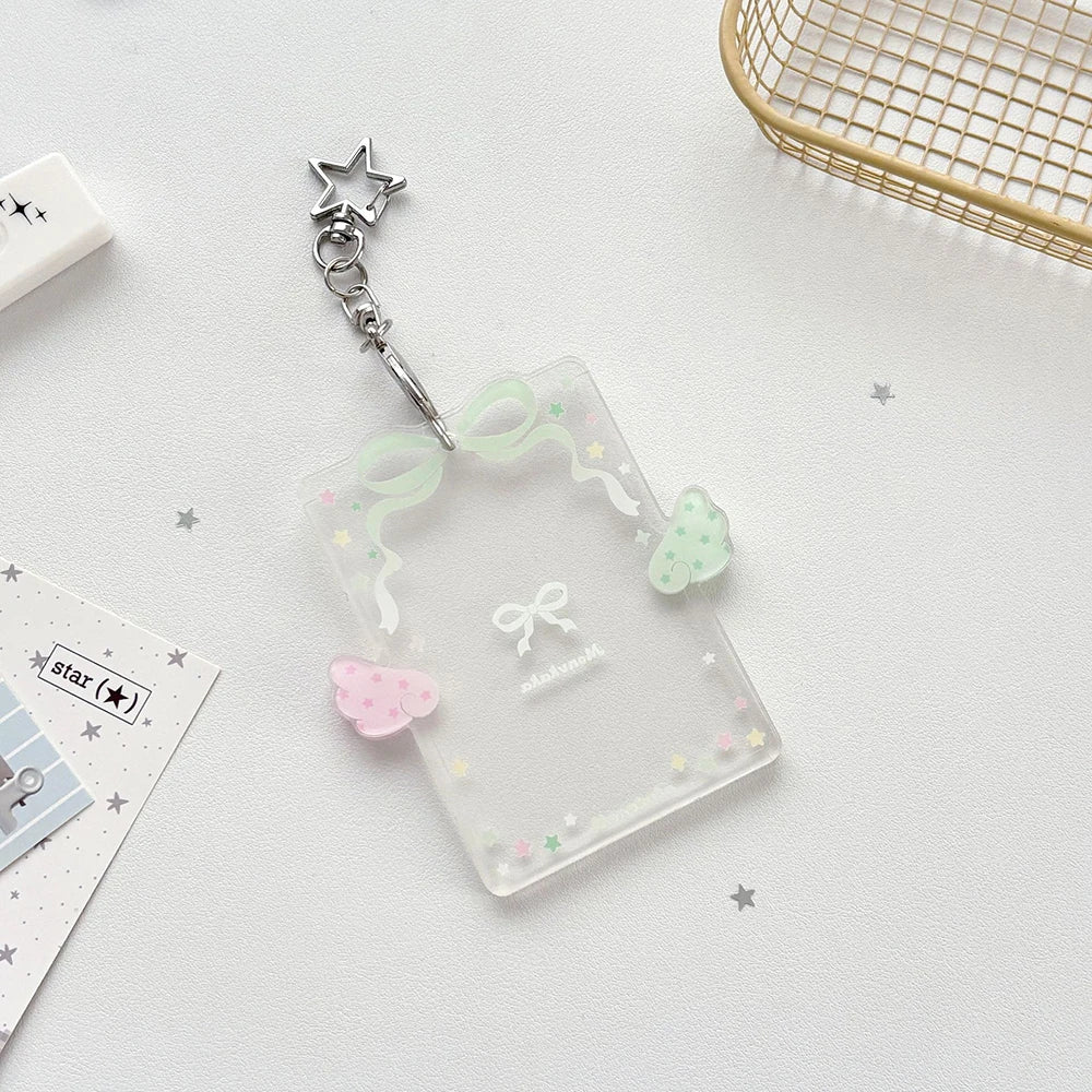 Clear acrylic card holder with a decorative bow and stars attached to a silver keychain.