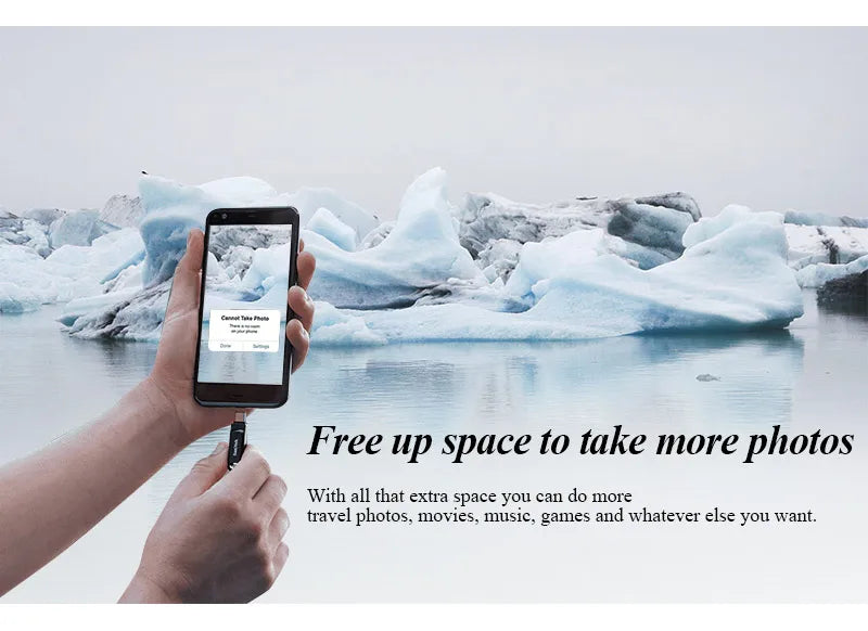 A hand holds a black smartphone displaying a screen, with icebergs and water in the background.