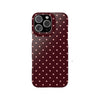 A dark maroon phone case with a pattern of small, light pink polka dots.
