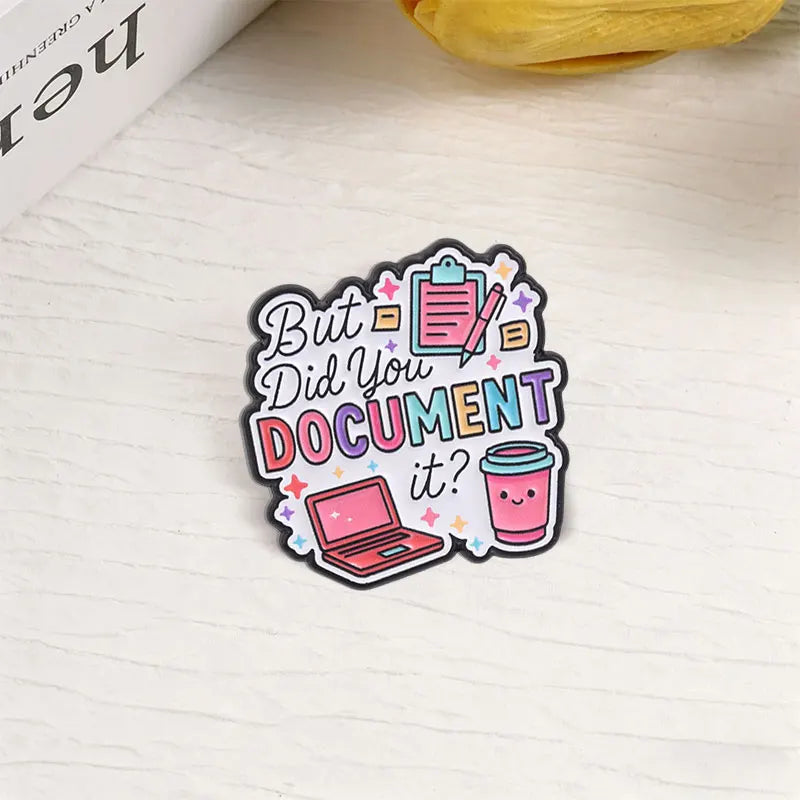 An enamel pin featuring the text But Did You Document It? surrounded by icons of a clipboard, pencils, and a laptop.