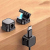 A set of magnetic cable clips, including a clip with a USB-C connector and a black cable, resting on a wooden surface.
