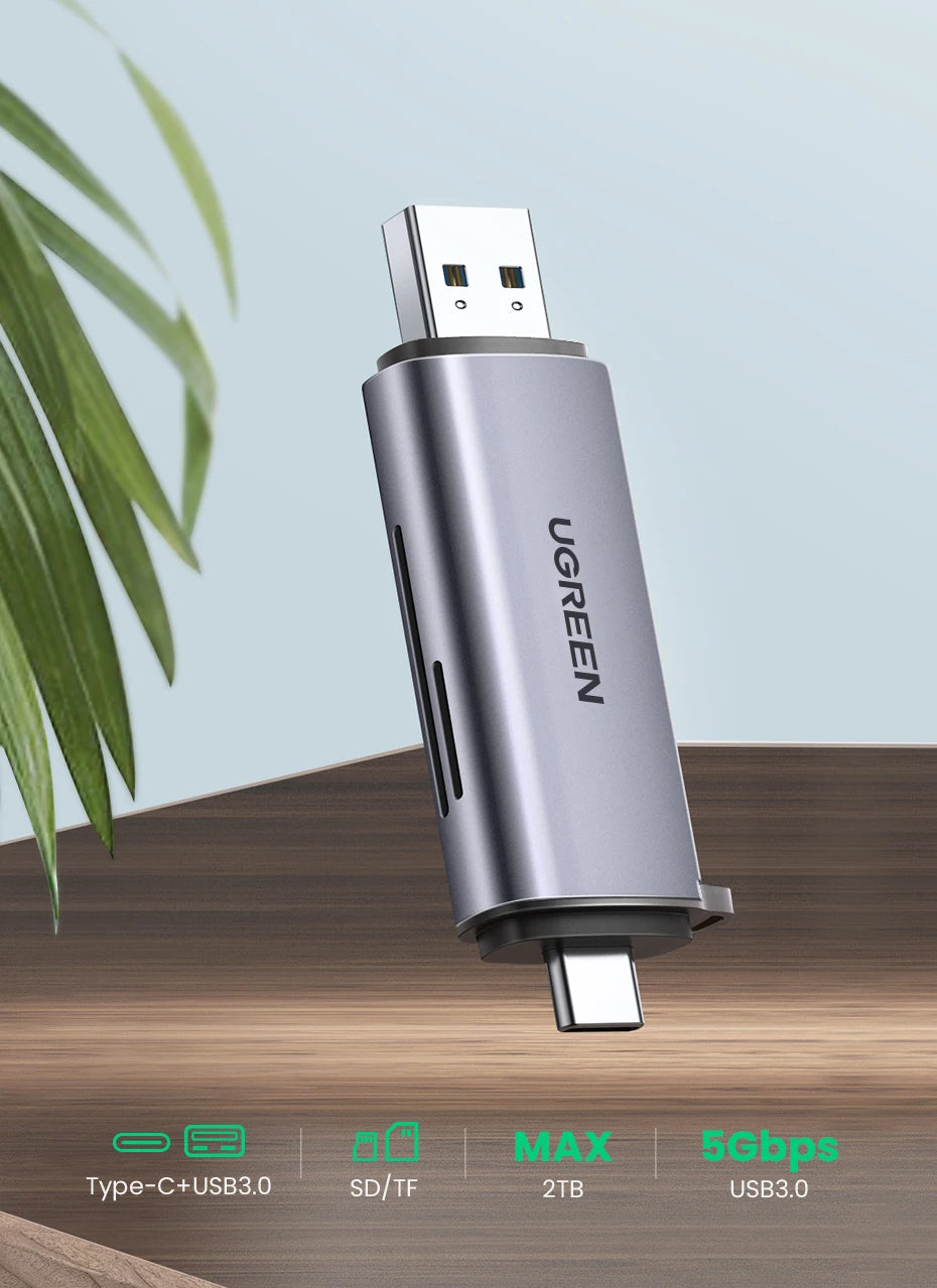 Lector de tarjeta USB-C plateado con ranura SD/TF y capacidad de 2TB, mostrado sobre una superficie de madera.