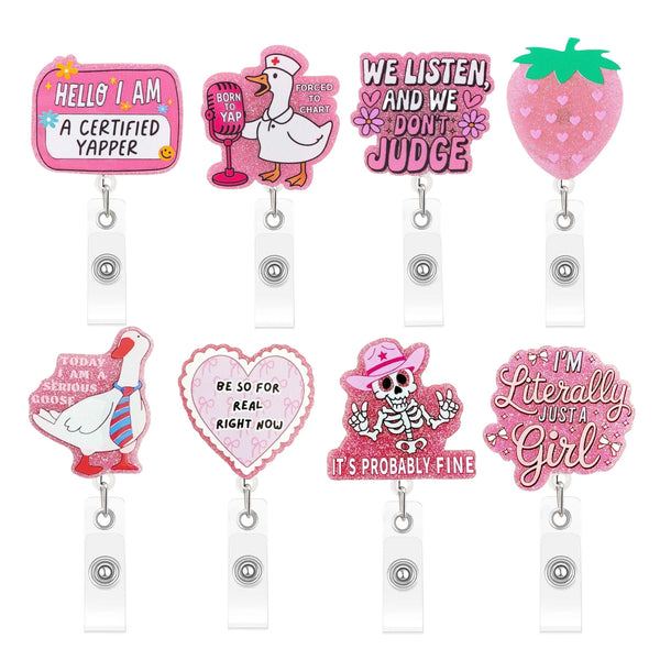 A set of five pink and white badge reels featuring various cute designs including a turkey, a heart, a skull, and a girl.
