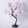 A black rose tree with pink artificial roses used as an LED night light.