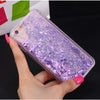 A hand holds a clear glitter purple phone case with heart and star designs against a dark background.