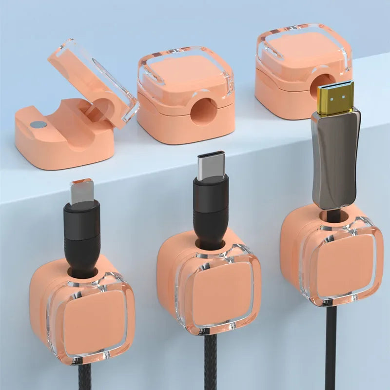 Several magnetic cable management clips in peach and clear plastic are shown attached to a vertical black cord.