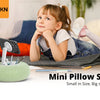 A small green pillow stand is shown next to a child and a smartphone in a home setting.