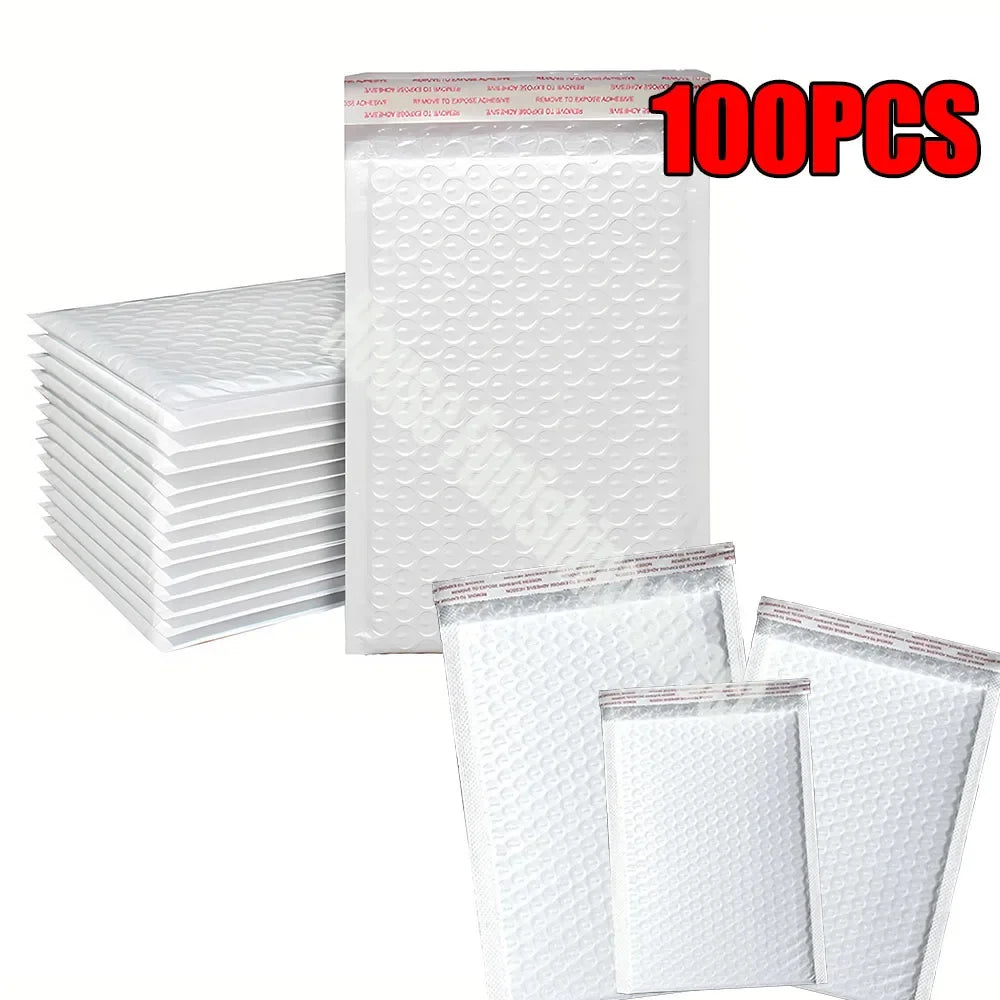 Une pile de 100 enveloppes blanches rembourrées pour l'expédition et les cadeaux.