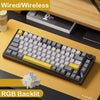 Schwarze mechanische Tastatur mit gelben Akzenten auf Holzoberfläche, die Kabel-/Funkfunktionen und RG hervorhebt