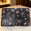 Schwarze Silikonhülle für ein Apple iPad mit rosa Band- und Herzmotiven auf der Rückseite.