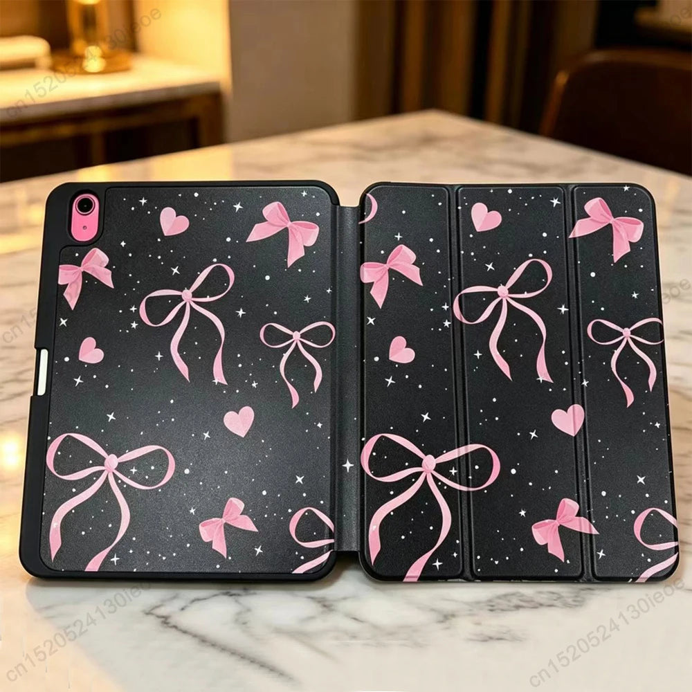 Schwarze Silikonhülle für ein Apple iPad mit rosa Band- und Herzmotiven auf der Rückseite.