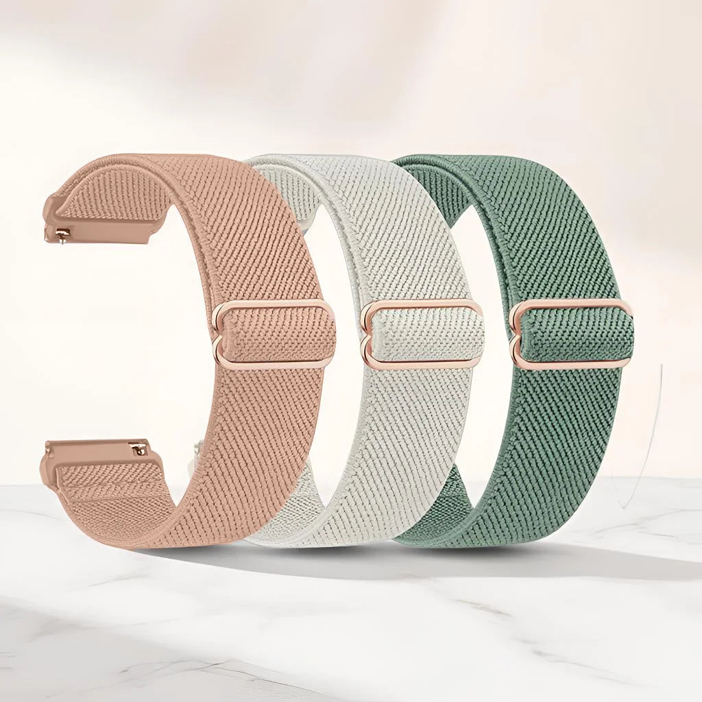 Three colored adjustable elastic sports bands in pink, beige, and green laid out on a white marble surface.