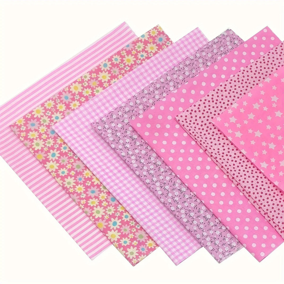 A collection of pink cotton patchwork fabric squares in various patterns including stripes, polka dots, and floral prints for