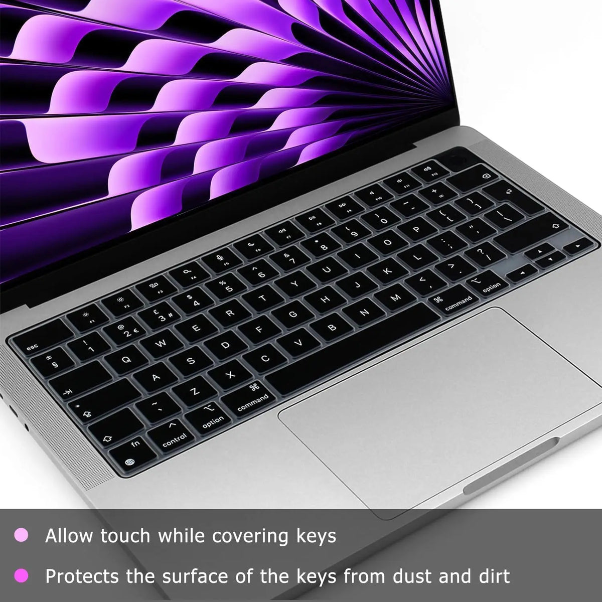 A silicone keyboard cover in purple and black protects the keys of a laptop.