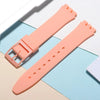 A peach-colored silicone watch strap is shown with replacement tools on a light blue background.