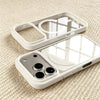 A clear acrylic phone case with a built-in MagSafe holder and a protective frame is shown on a light textured surface.