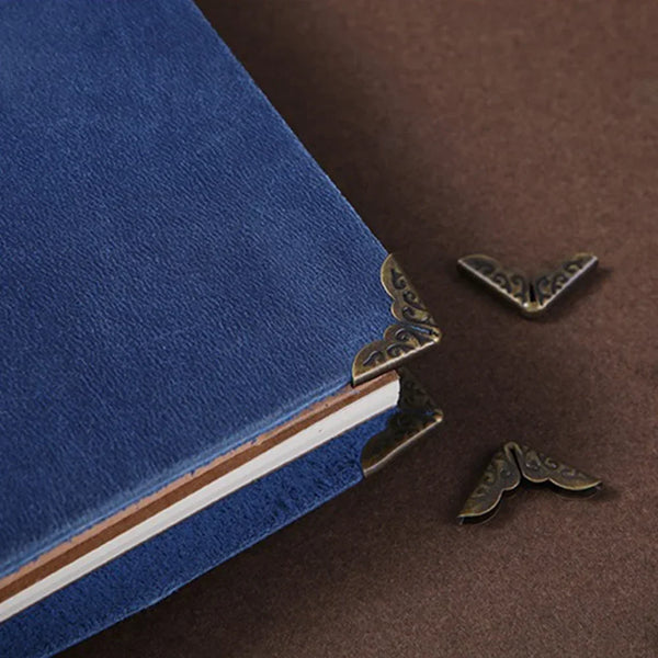 A close-up of a dark blue book corner protected by vintage metal protectors.