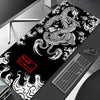 A black desk mat featuring a white and gray Japanese dragon design for gaming.