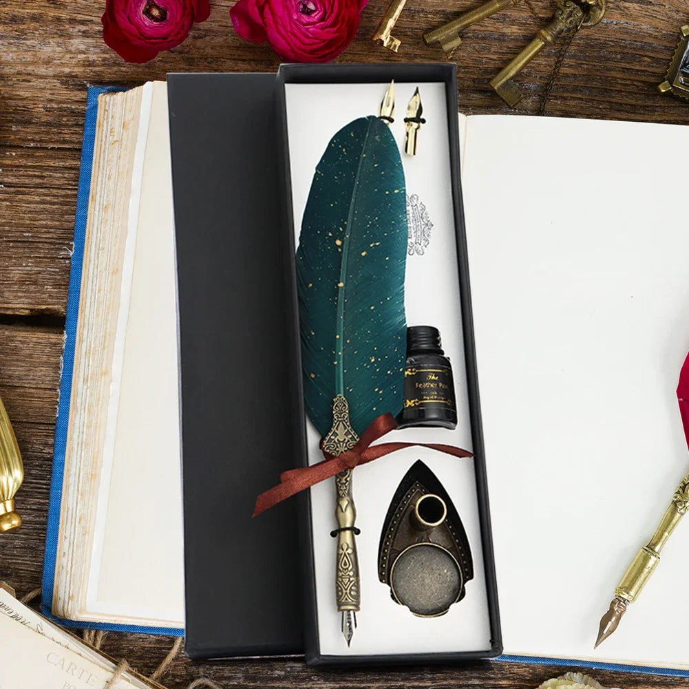 A black box containing a retro calligraphy feather dip pen set with gold accents and a dark green feather on a white backgrou