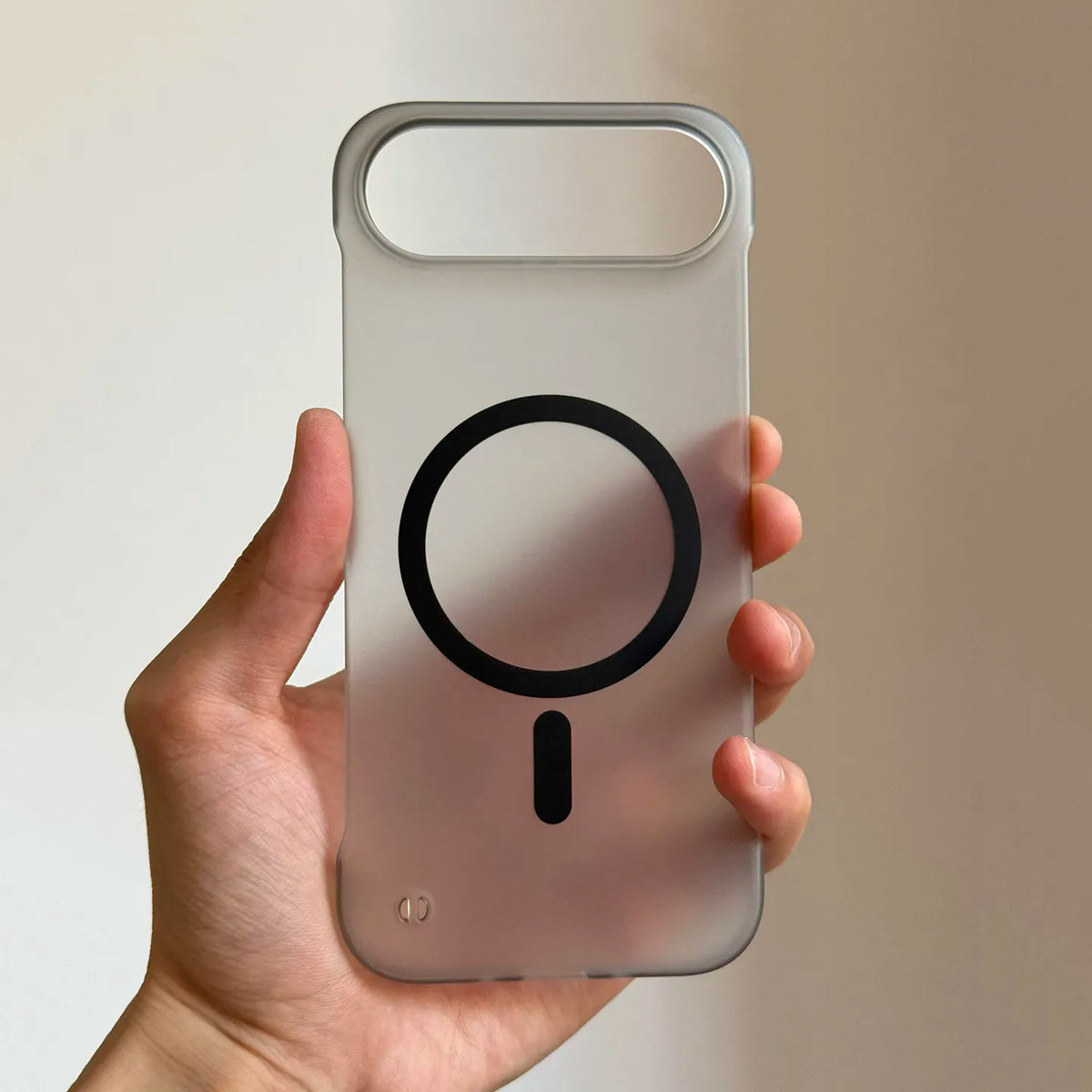 A hand holds a clear silicone magnetic phone case for an iPhone, featuring a black magnifying glass design.