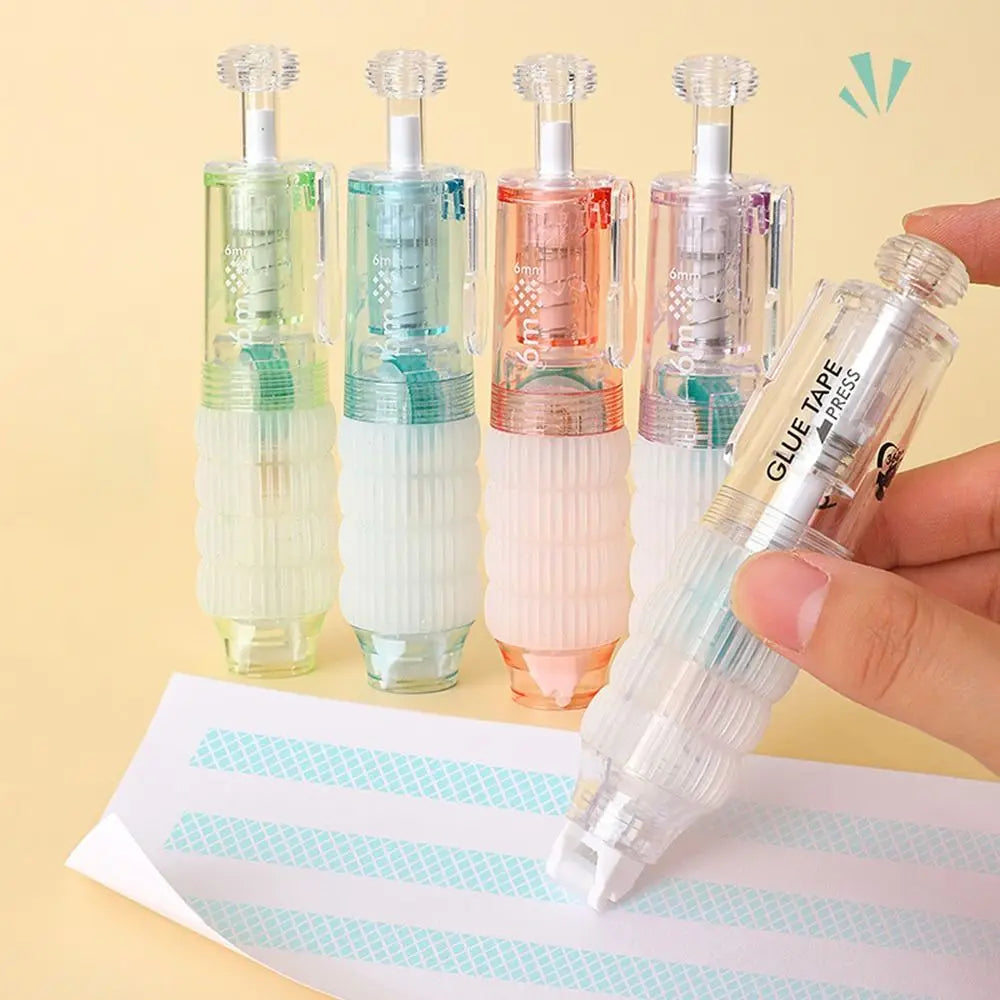 A hand holds a clear double-sided quick dry dot glue pen with four colored tips on a white paper.