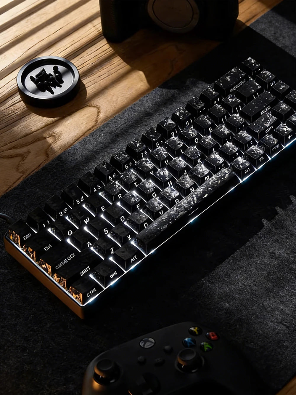 A close-up shot of a backlit mechanical keyboard with carbon fiber keycaps resting on a dark fabric surface.