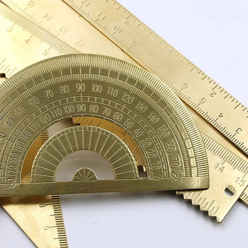 A brass drafting set with a graduated arc and ruler shown against a white background.