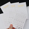 A hand holds a set of metallic 3D star nail art stickers on white cards.