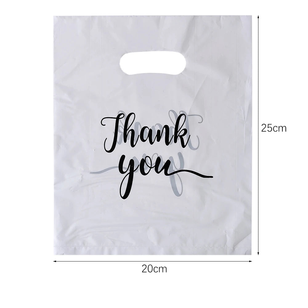 A white thank you gift bag with black script writing on it, showing its dimensions.