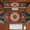 A vintage Persian rug gaming mouse pad with a non-slip rubber base placed on a wooden desk next to a computer monitor and key