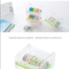 Dispenser de plástico transparente con cintas washi de varios colores y un cortador para manualidades.