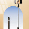 An ultra-long selfie stick with a smartphone mounted on top is displayed against a light background.