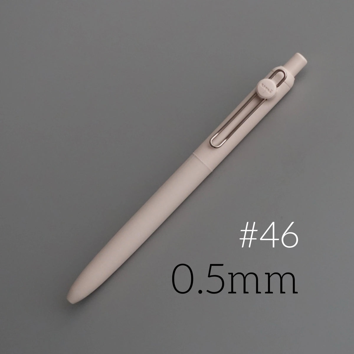 A light beige precision gel pen with a silver clip and a visible 0.5mm tip, shown diagonally on a gray background.