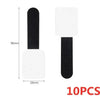 A set of ten white and black reusable adhesive cable ties for desk organization.