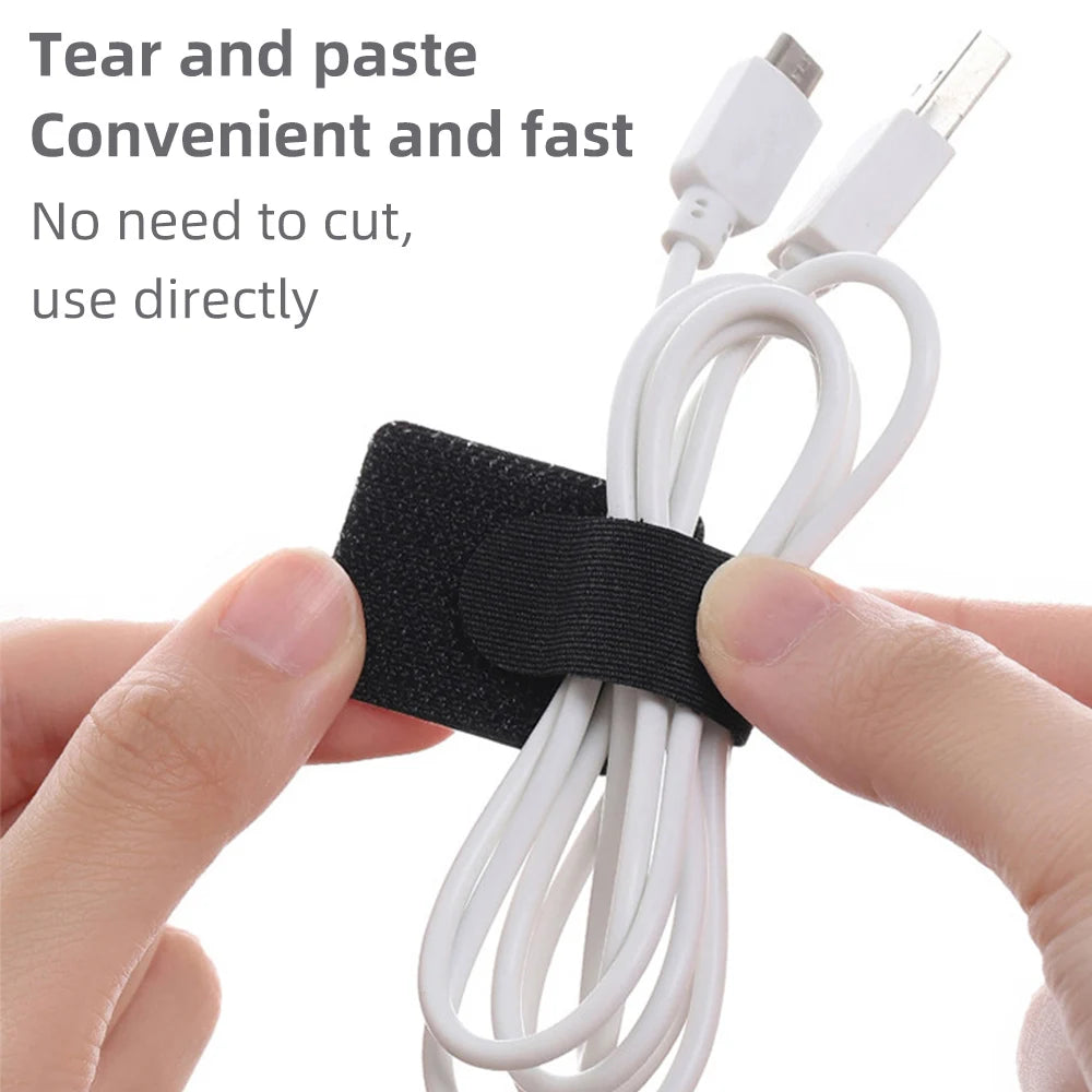 Hands are tearing and pasting a white cable organizer kit for desks and electronics.