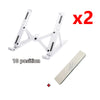 Two white foldable adjustable laptop stands and a small red plus sign