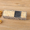 A rectangular wooden stamp seal set with numbered days and a dark square, placed on a light wooden surface.