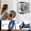 A woman is using a 360° rotating tablet wall mount stand to exercise with a medicine ball.