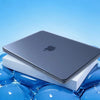 A silver Apple laptop is shown resting inside a white protective case, with blue liquid surrounding the object.