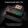 A black mechanical keyboard with customizable RGB lighting and a pink charm resting on it.