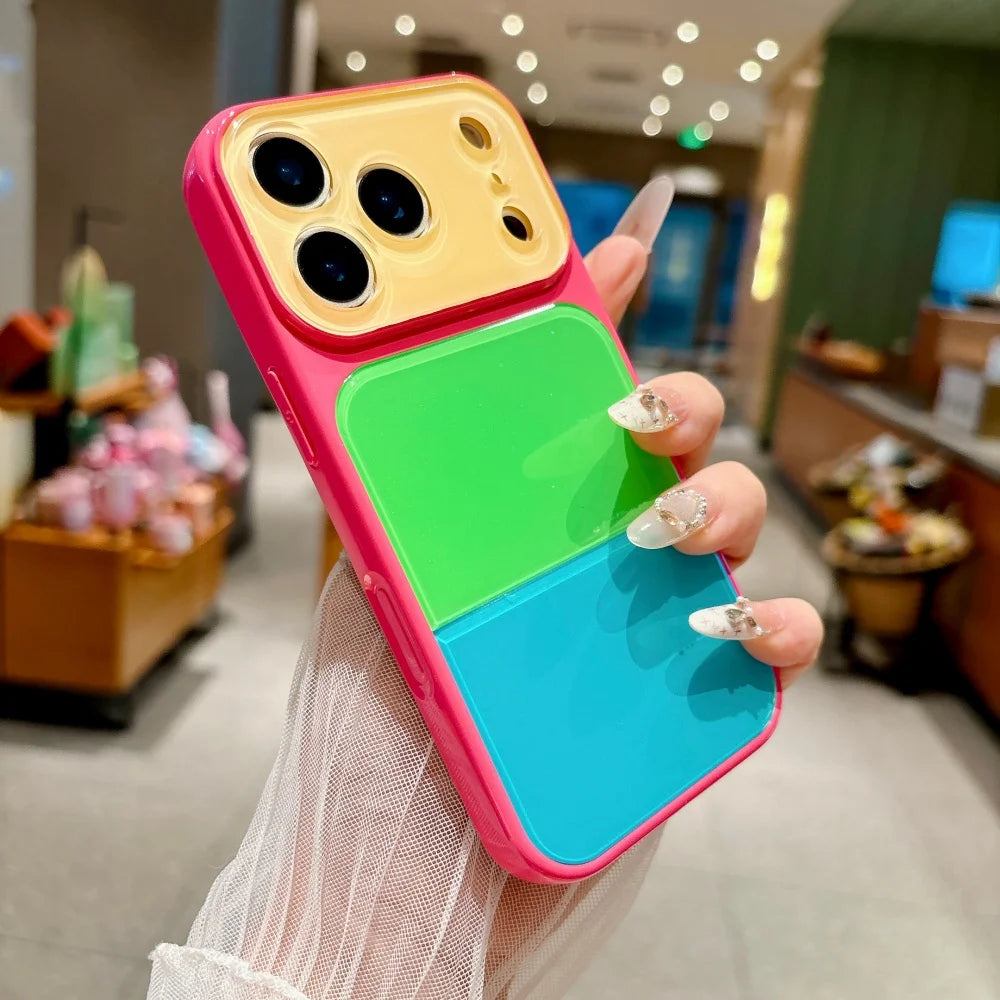 A hand holds a pink and yellow acrylic phone case with a green and blue layered design.