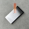 A silver money clip wallet is shown with a flame effect on its surface.