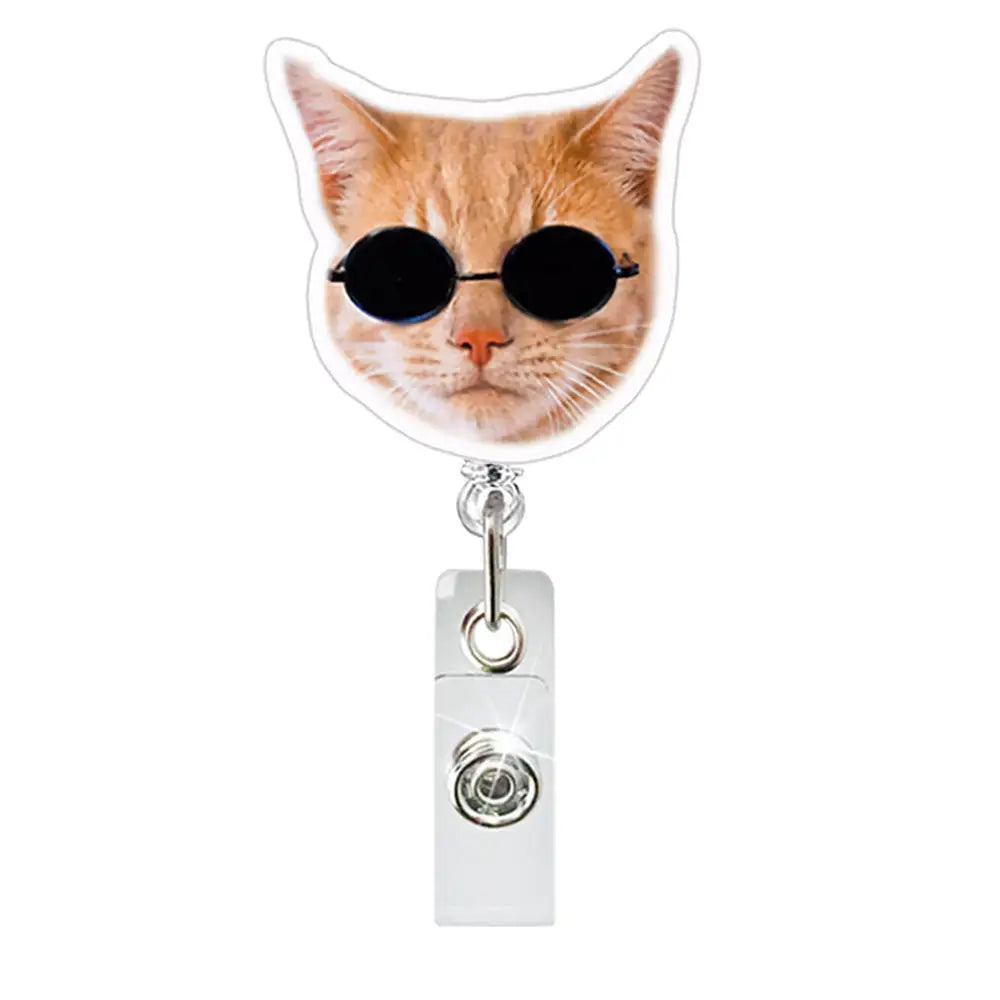 A cat wearing black sunglasses is featured on a clear ID badge holder with a crocodile clip.